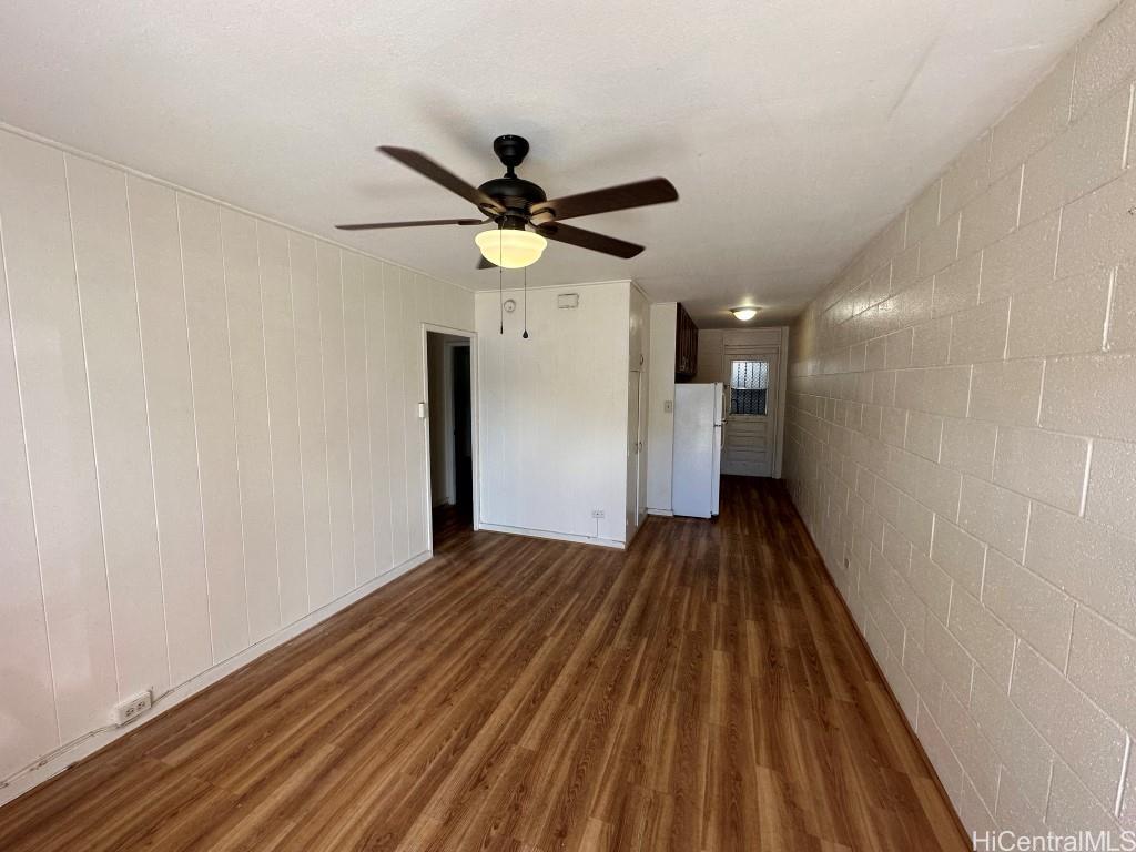 a view of a big room with wooden floor and a ceiling fan