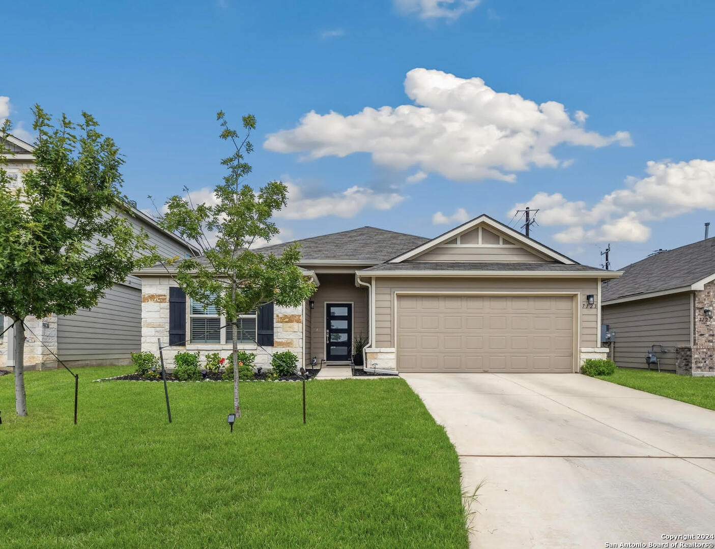 a front view of a house with a yard and garage