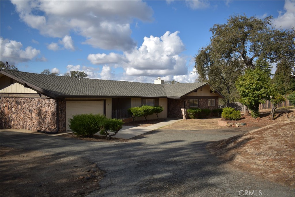 a front view of house with yard and trees around