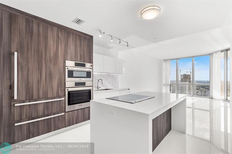 a kitchen that has a microwave and a stove top oven