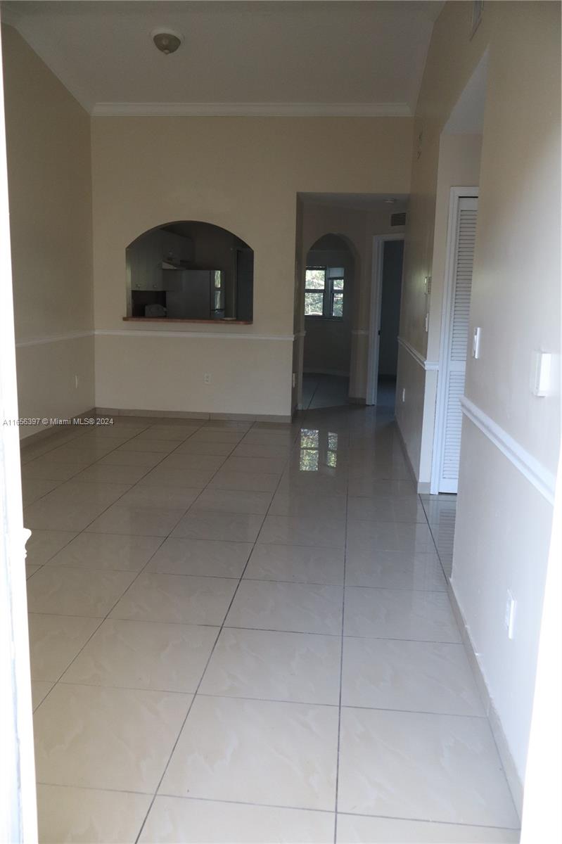 a view of a hallway with entryway and livingroom with furniture