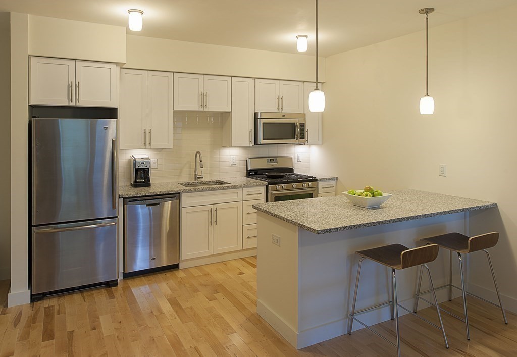 a kitchen with a sink stainless steel appliances and white cabinets