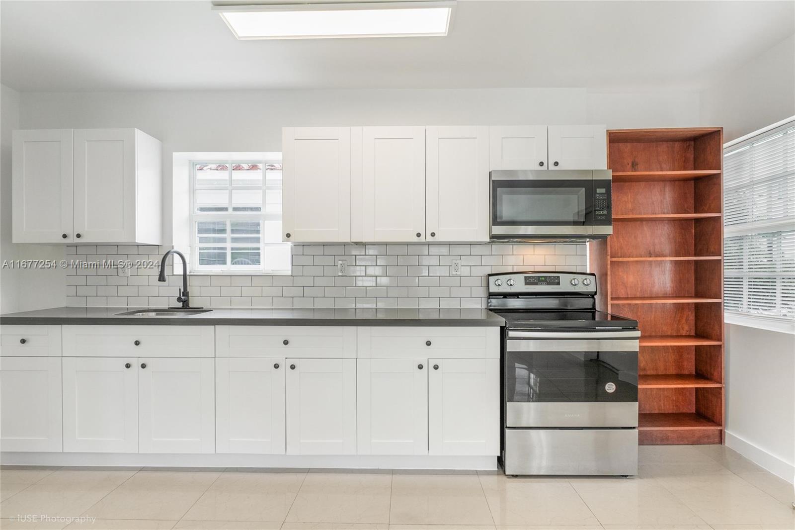 a kitchen with stainless steel appliances a stove a sink and white cabinets