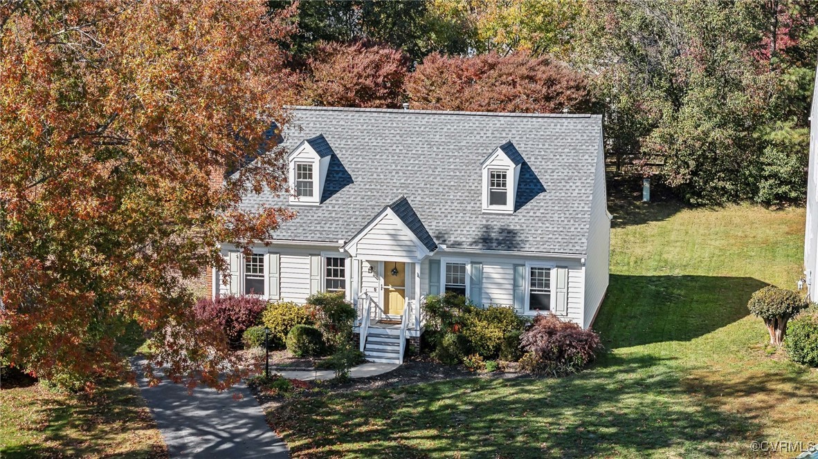 a front view of house with yard and trees in the background