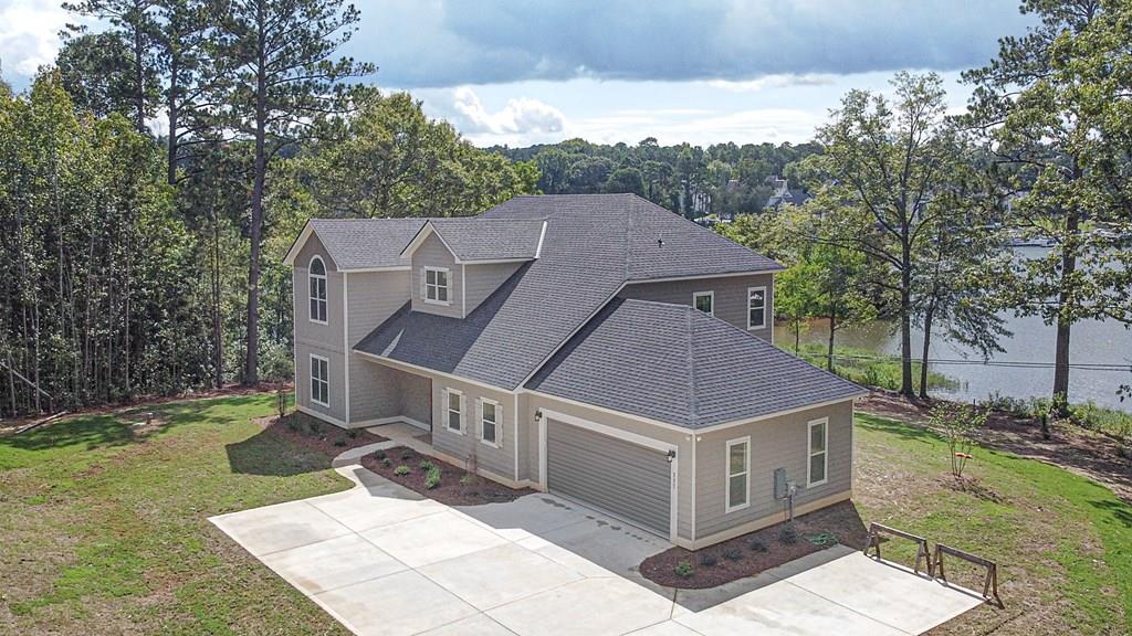 a aerial view of a house in a big yard with large tree