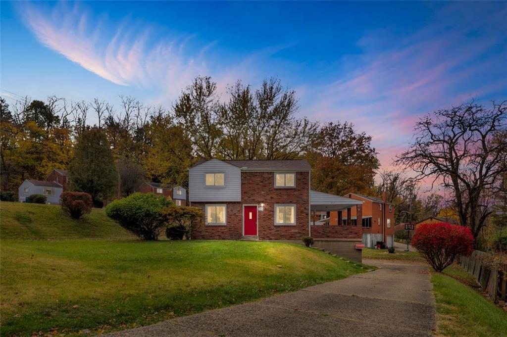 a view of a house with a yard fire pit and a patio