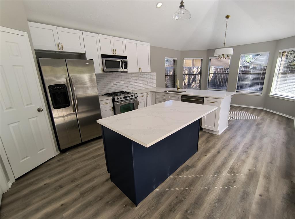 a kitchen with a sink refrigerator and microwave