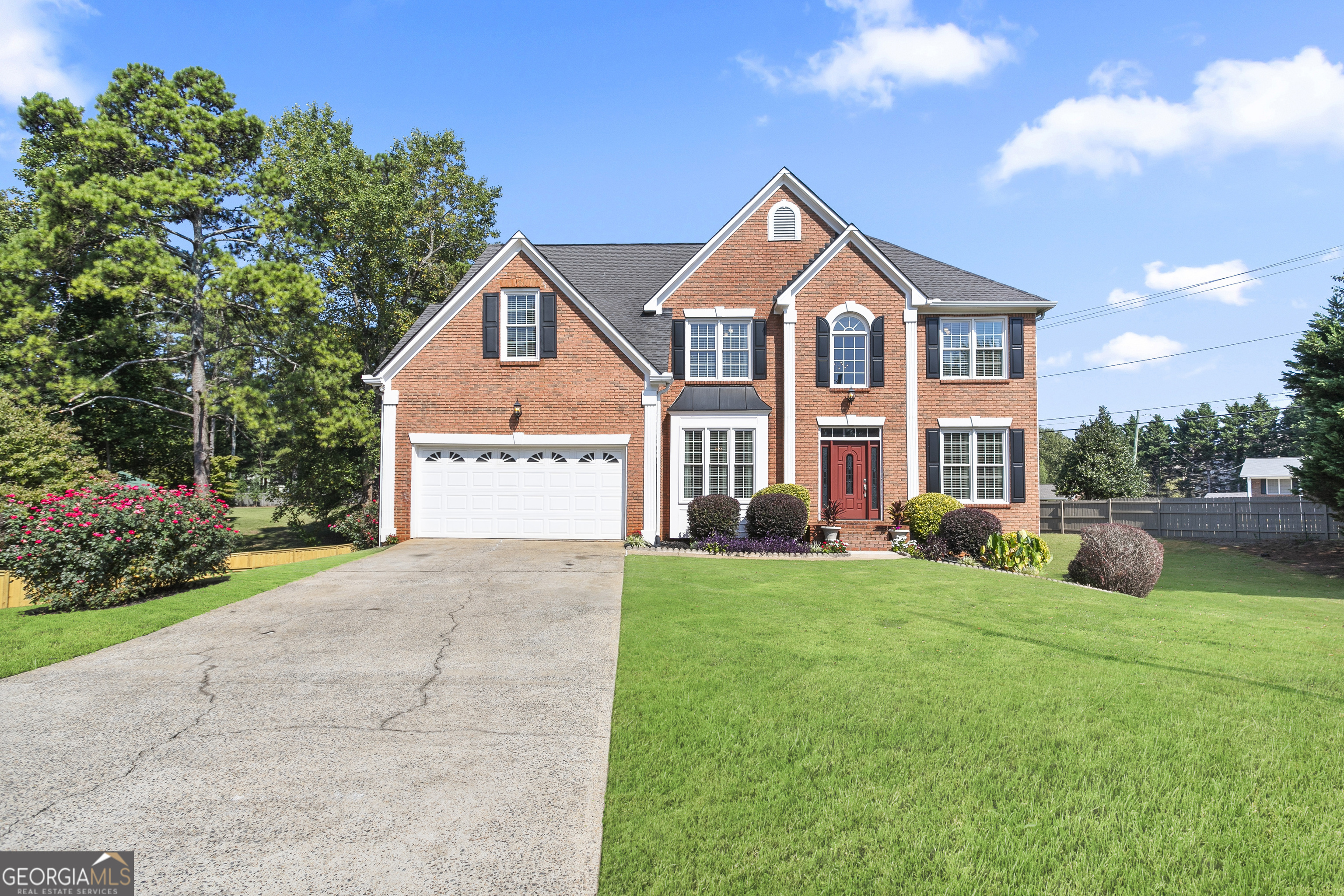 a front view of a house with yard and green space