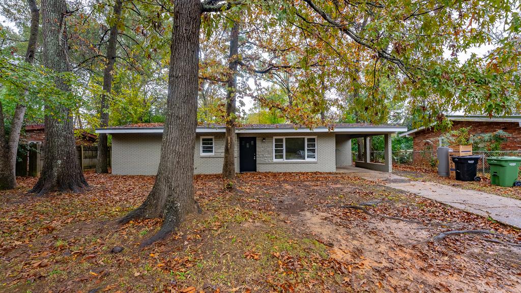 a view of a house with a yard and large tree