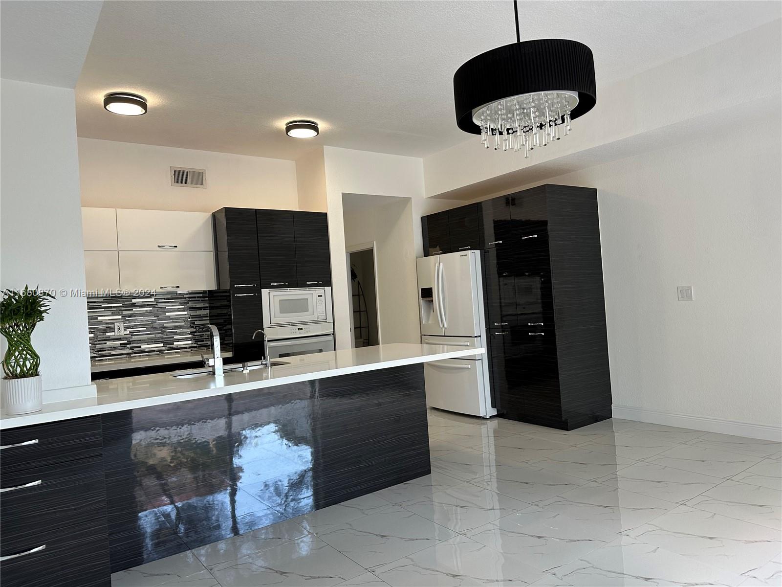 a living room with stainless steel appliances kitchen island granite countertop furniture and a flat screen tv