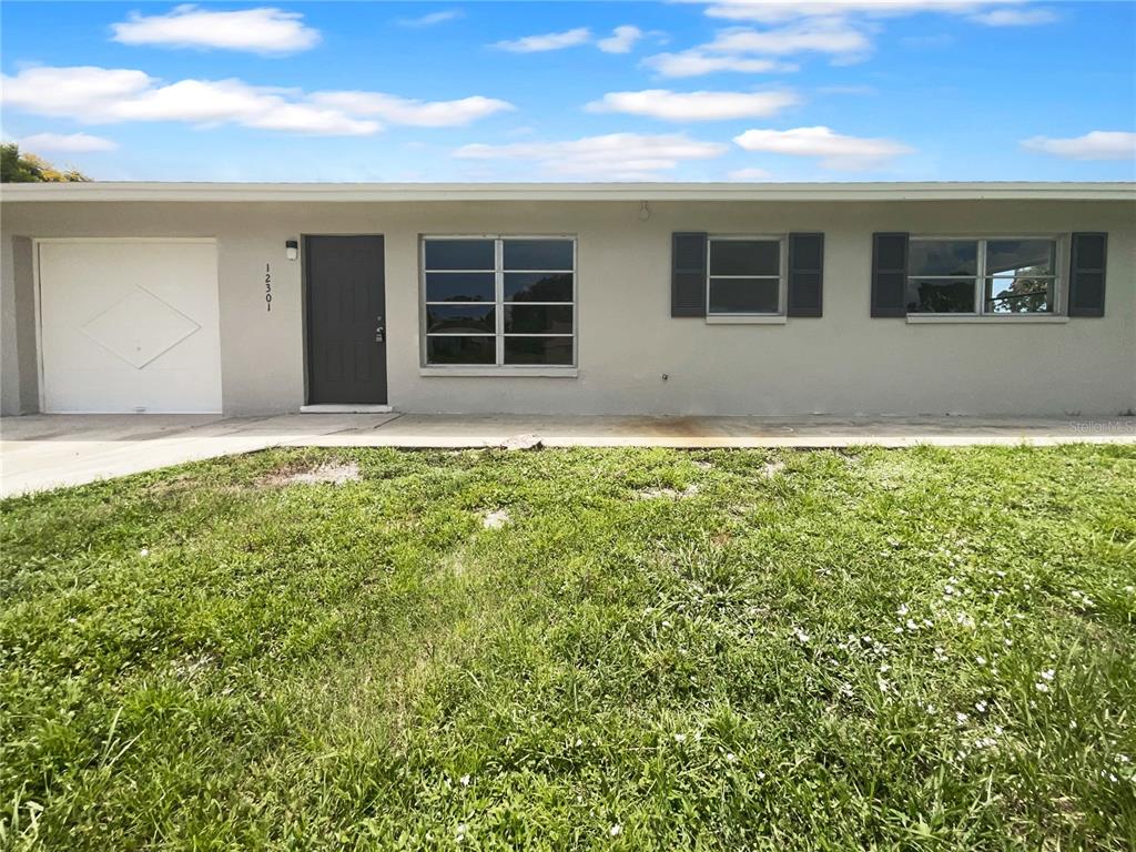 a view of an house with backyard space and windows