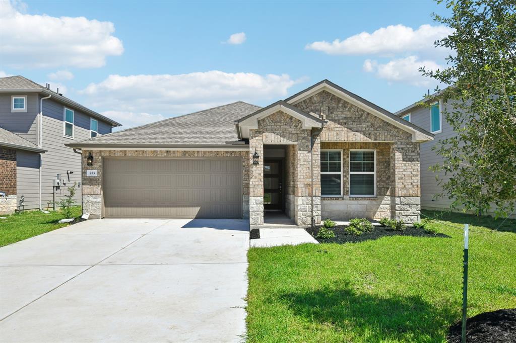 a front view of a house with a yard and garage