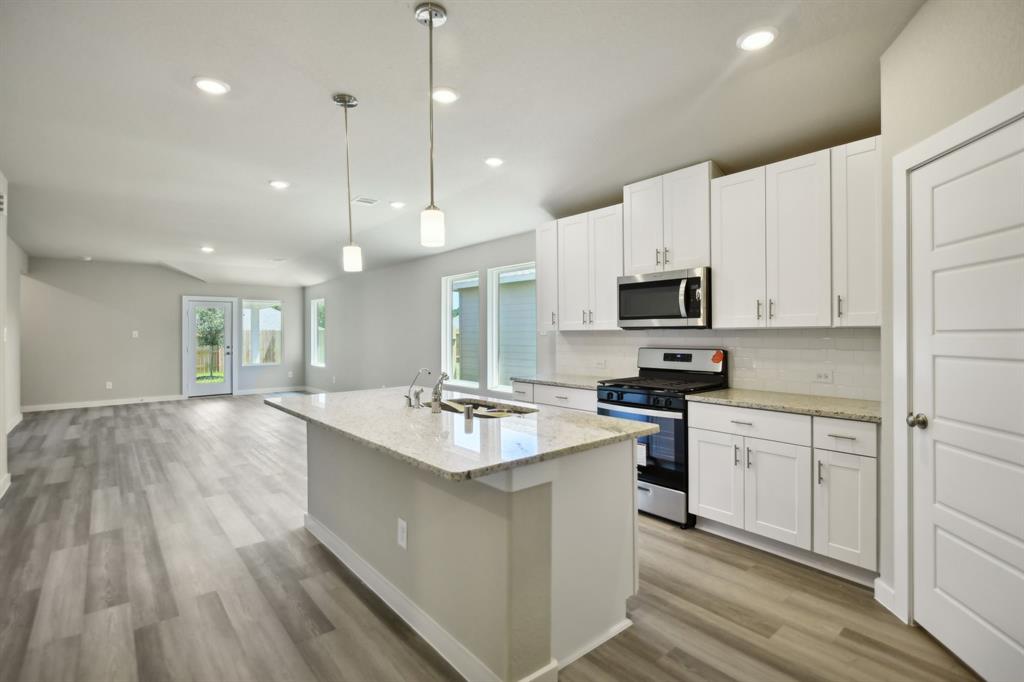 a kitchen with kitchen island white cabinets and appliances