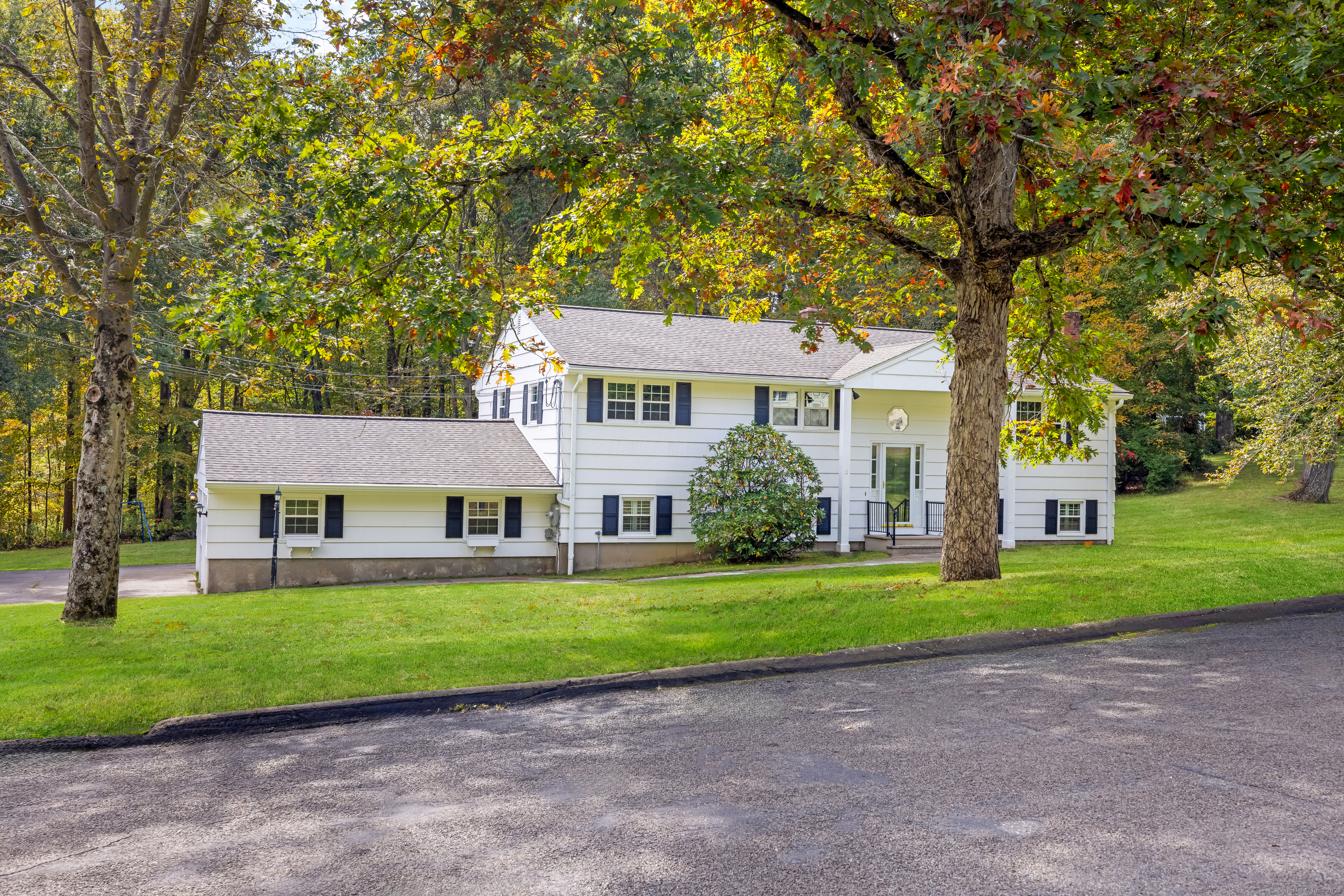 a front view of a house with a yard and trees