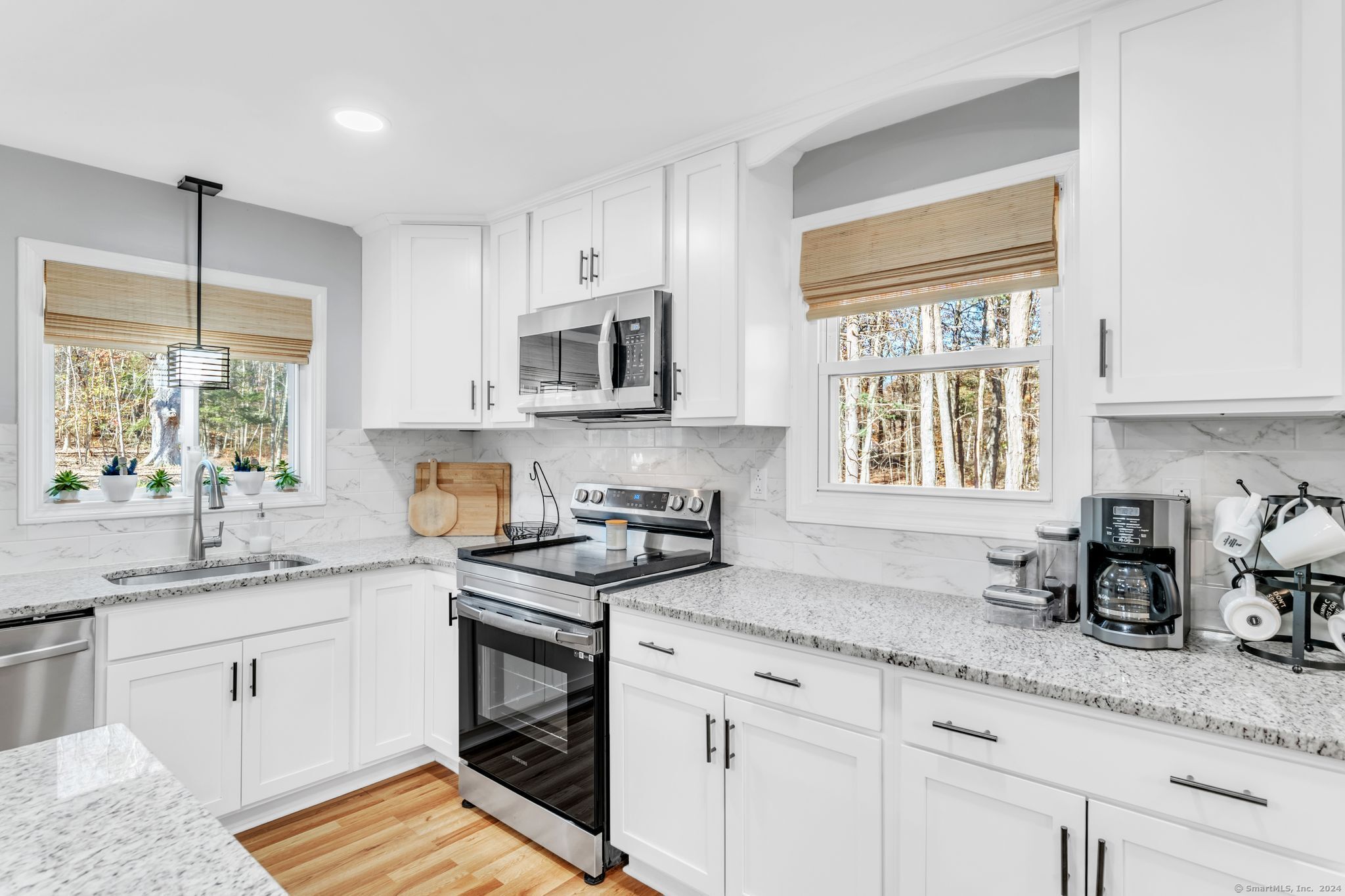 a kitchen with granite countertop a sink appliances cabinets window and a counter top space