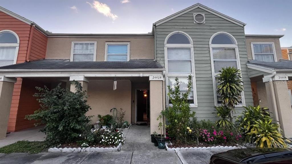 a front view of a house with plants