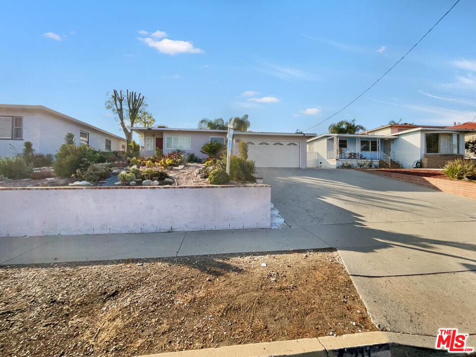 a view of a house with a yard and a street