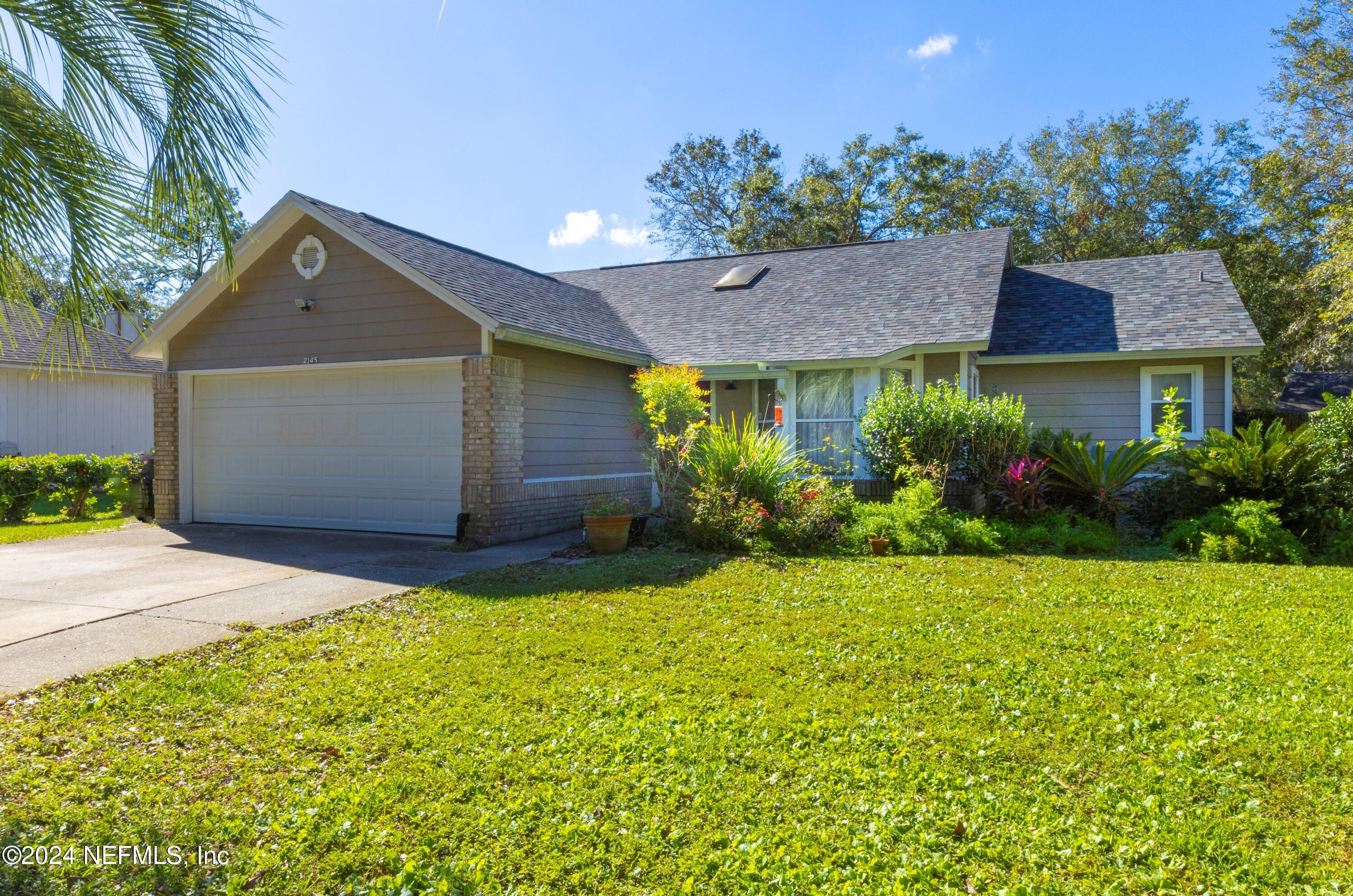 a front view of a house with a yard and garage