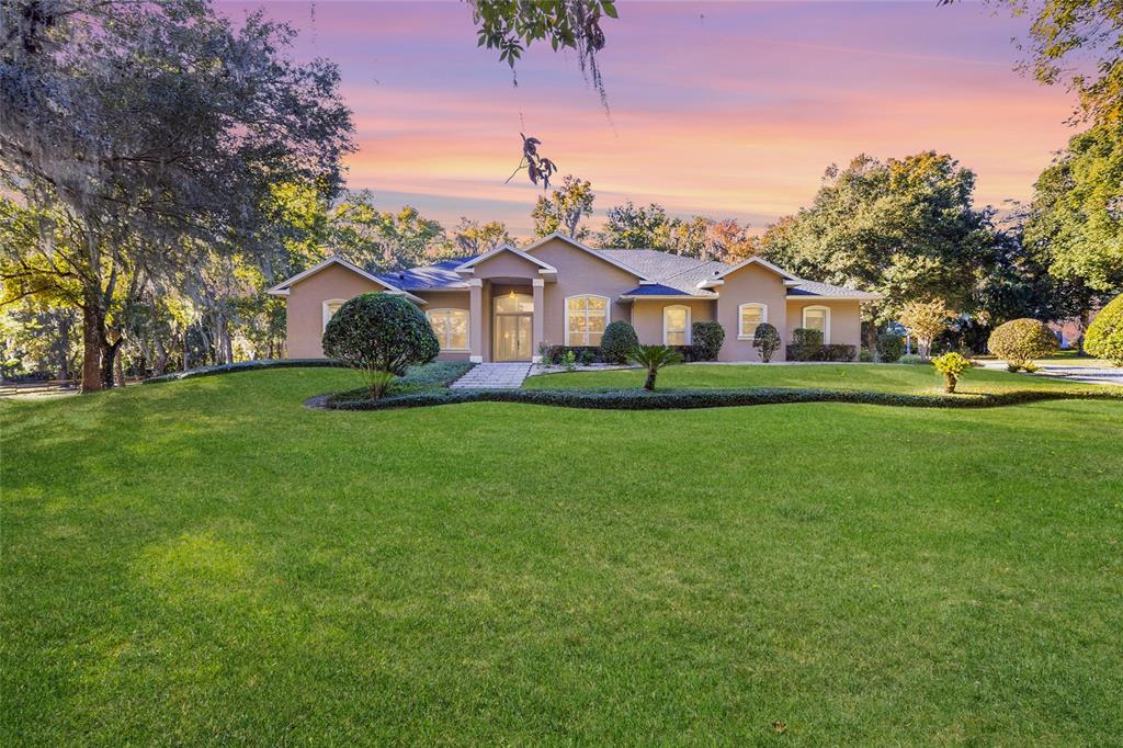 a front view of a house with a yard and trees