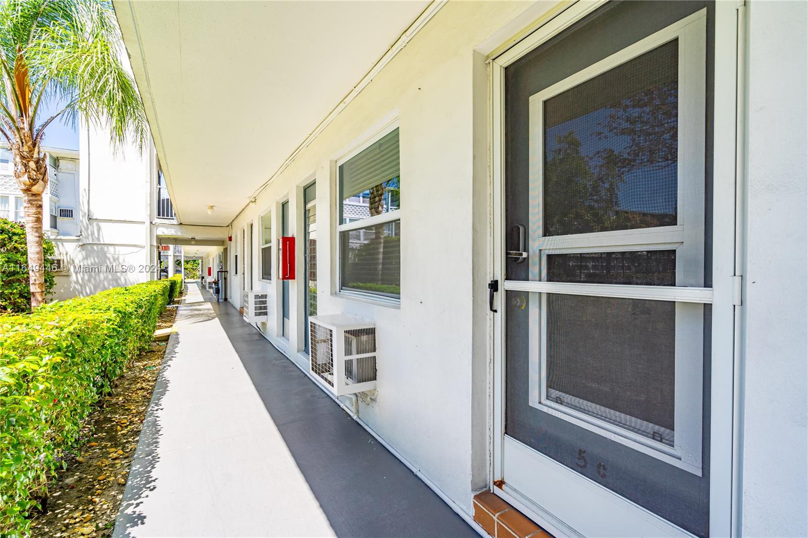 a narrow alley with a glass door and shower