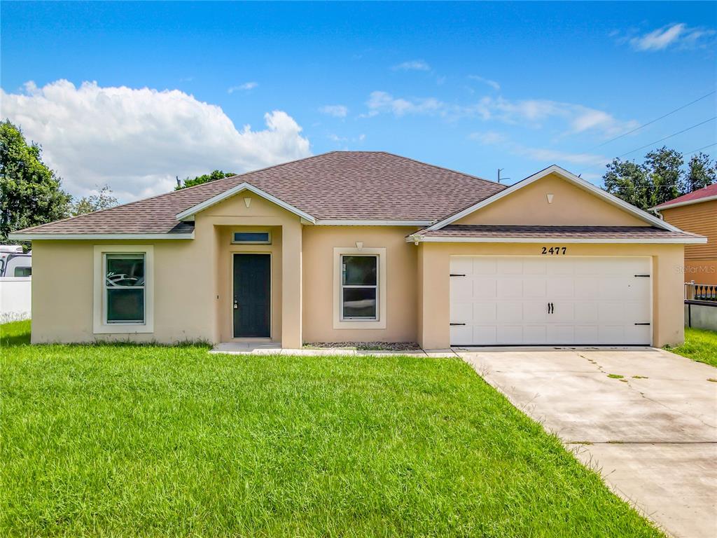 a front view of a house with a yard and garage