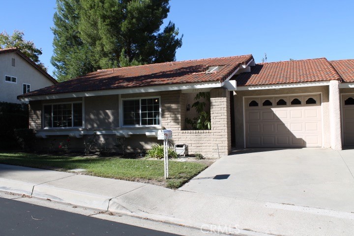 a front view of a house with a yard and potted plants