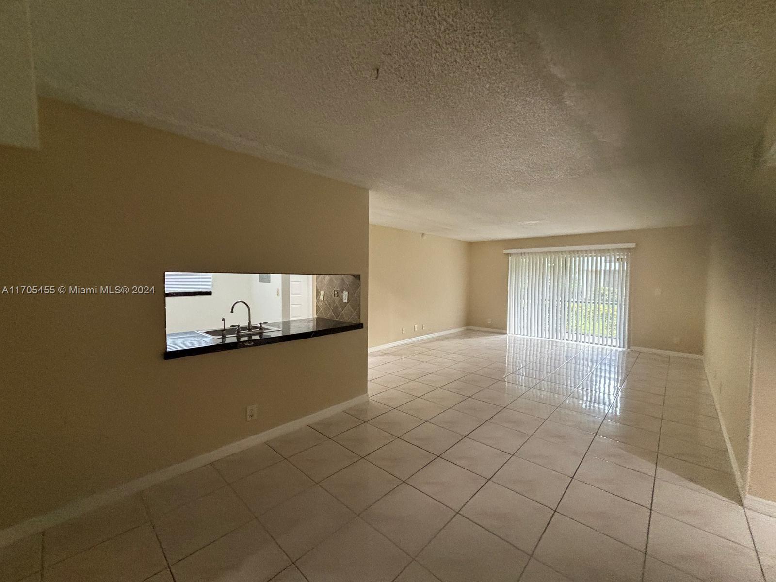 a view of an empty room with kitchen