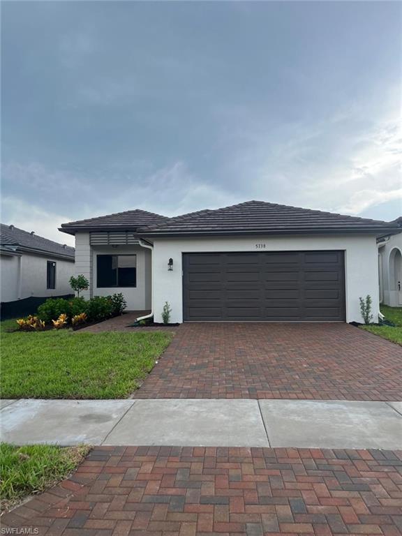 View of front of property with a garage and a front yard