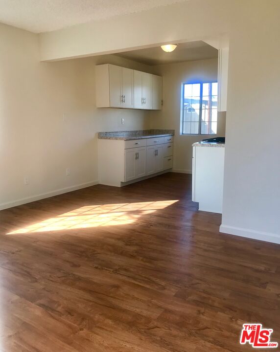 a kitchen with granite countertop wooden floors and wide window