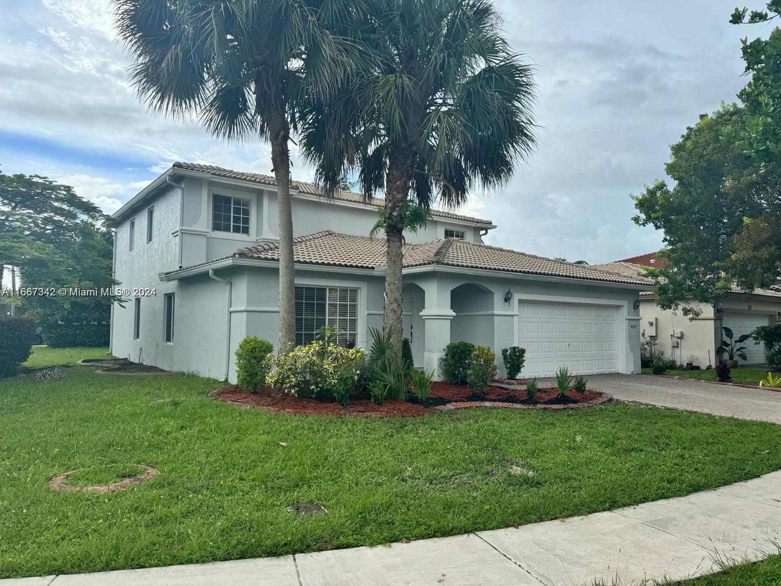 a front view of a house with a garden and plants