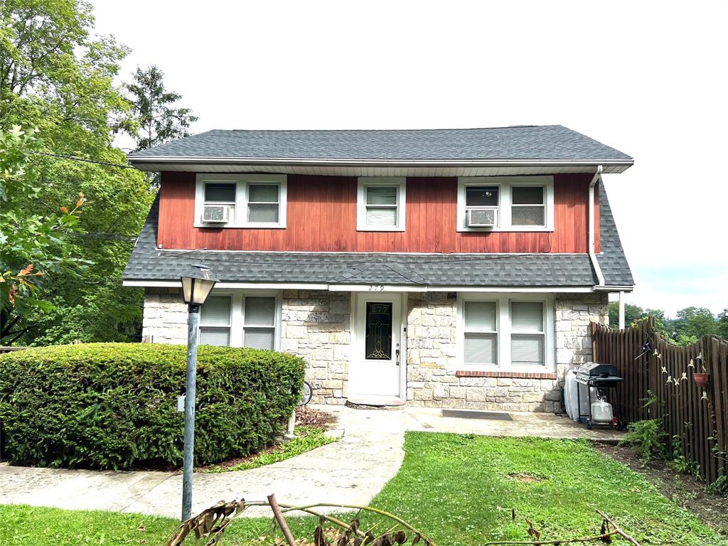 View of front of home featuring a front lawn and cooling unit