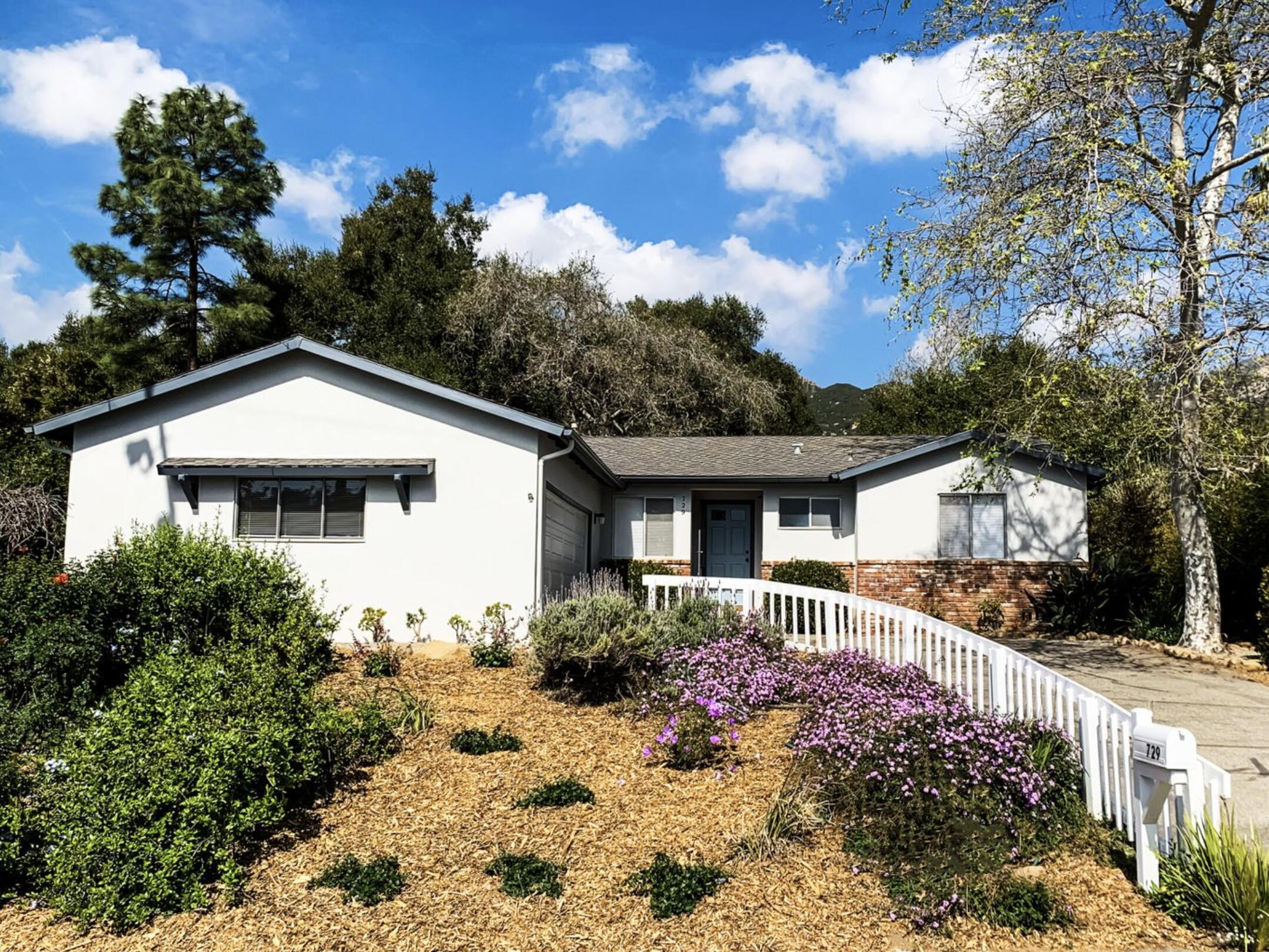 a front view of house with yard and trees around