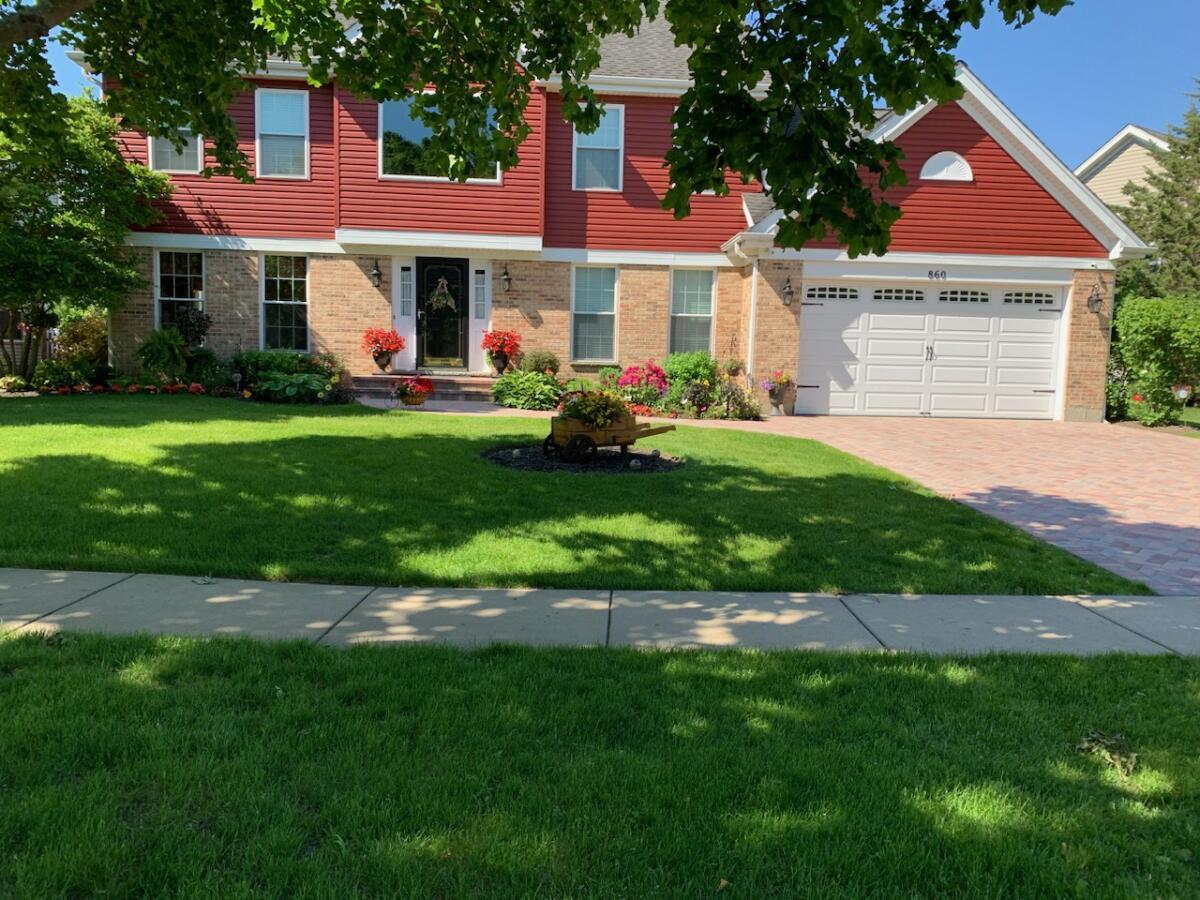 a front view of a house with a garden and plants