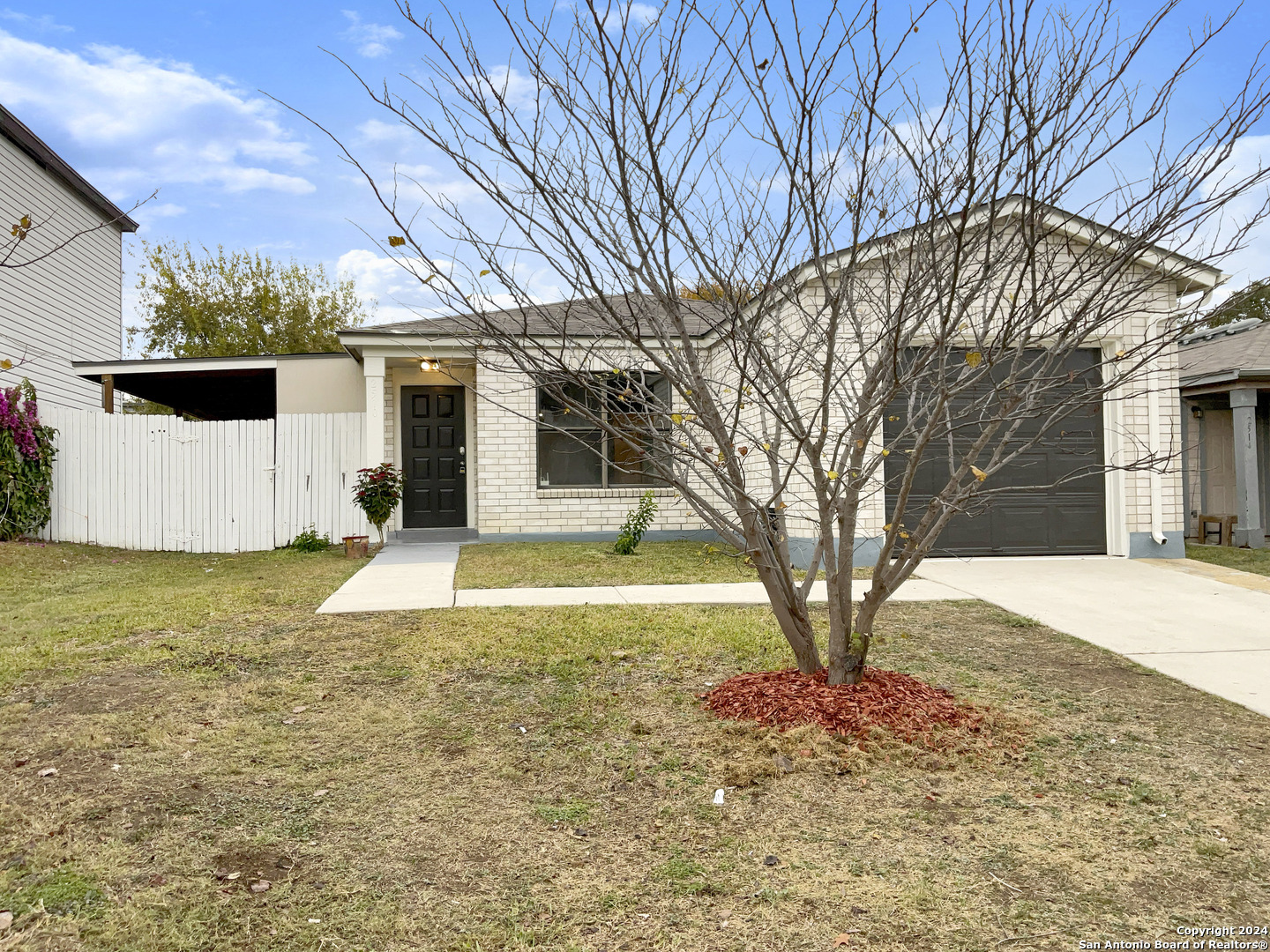 a view of a house with backyard and tree