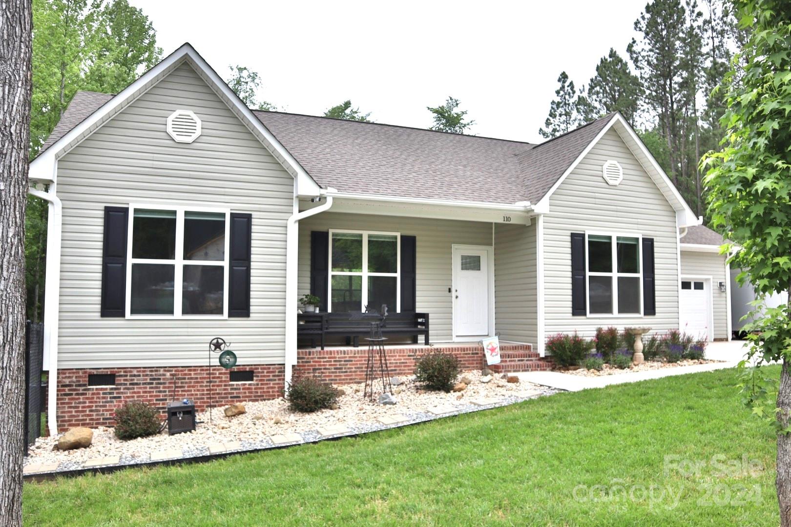 a front view of a house with a yard and outdoor seating