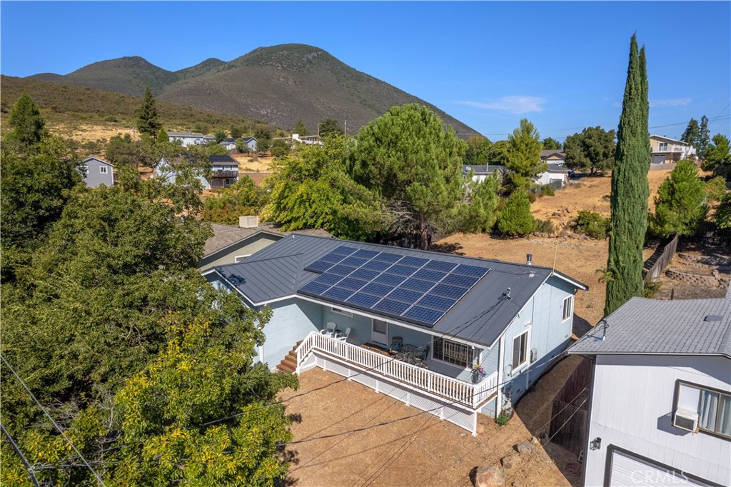 an aerial view of houses with a yard and mountain view