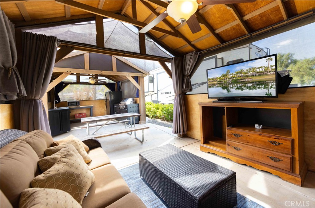 a living room with furniture a flat screen tv and a floor to ceiling window