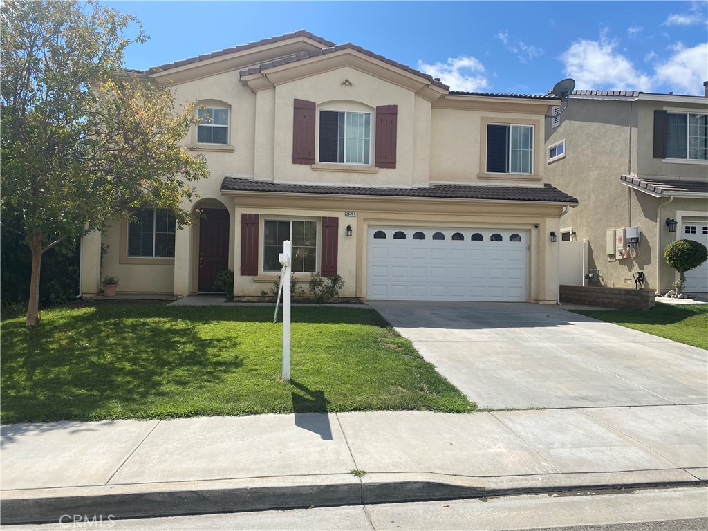 a front view of a house with a yard and a garage