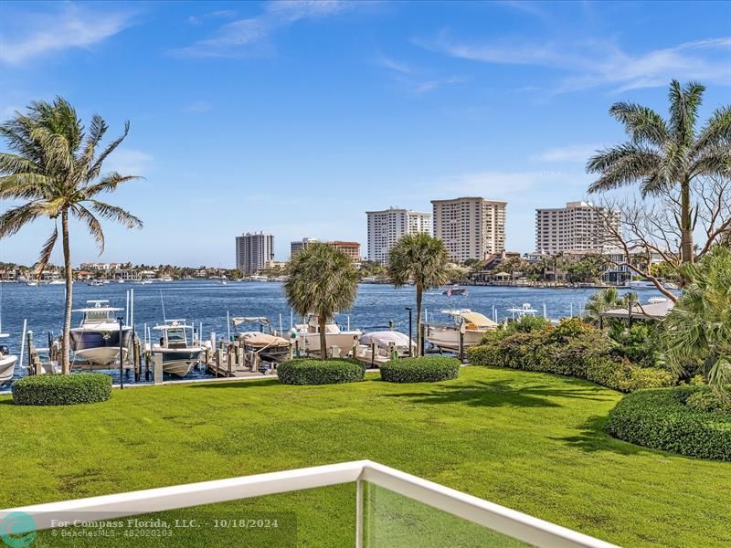 a view of a house with a big yard and palm trees