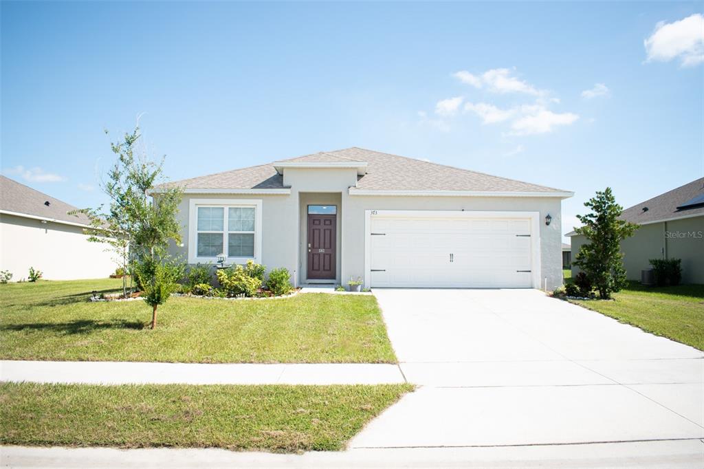 a front view of a house with a yard and garage