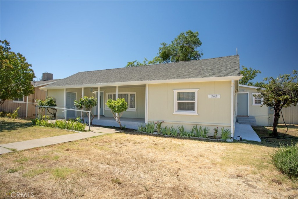 a front view of a house with a yard and potted plants