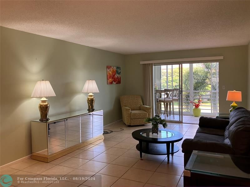 a living room with furniture a table and a large window