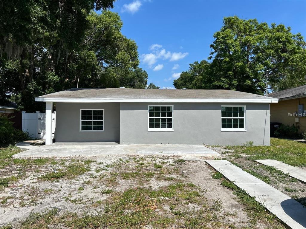 a front view of house with yard and trees in the background