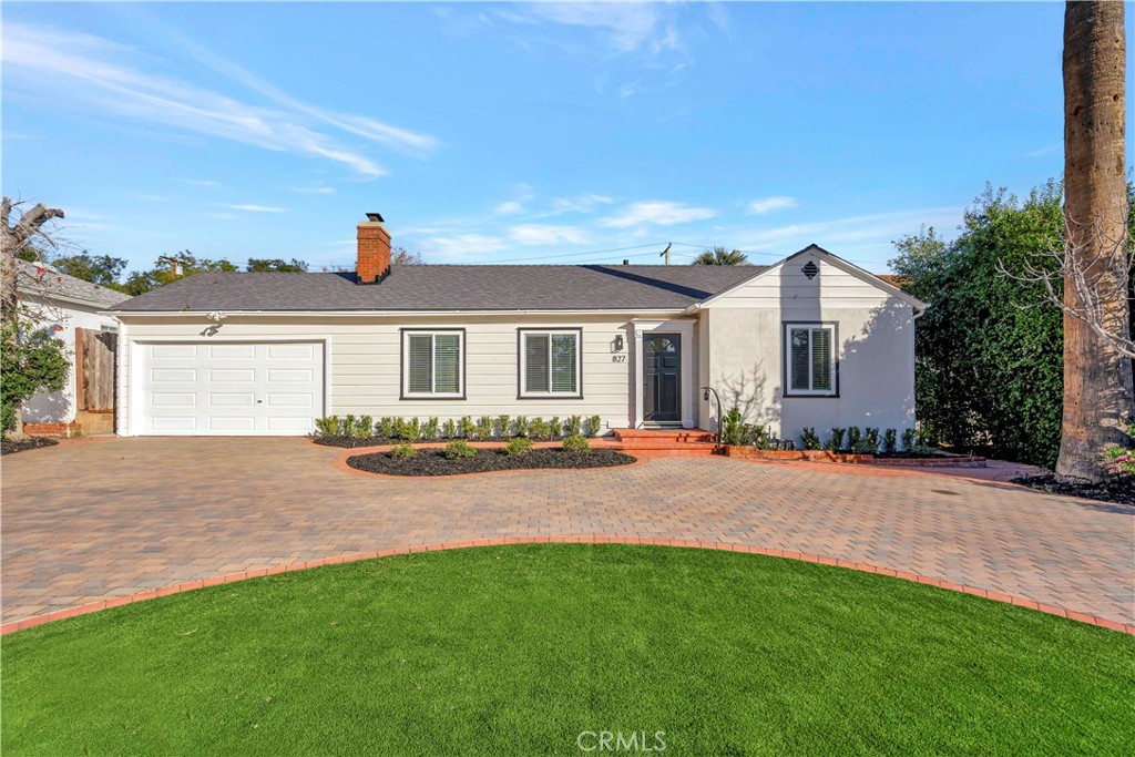 a front view of a house with yard and green space