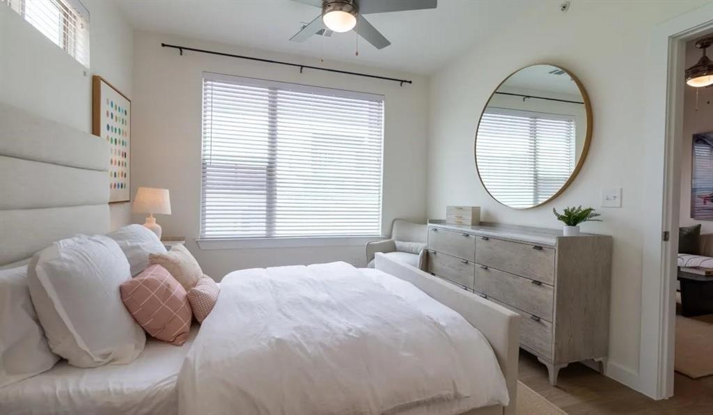 a bedroom with a bed a mirror and a large window