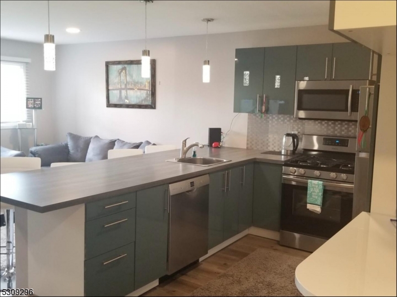 a kitchen with granite countertop a sink stainless steel appliances and cabinets