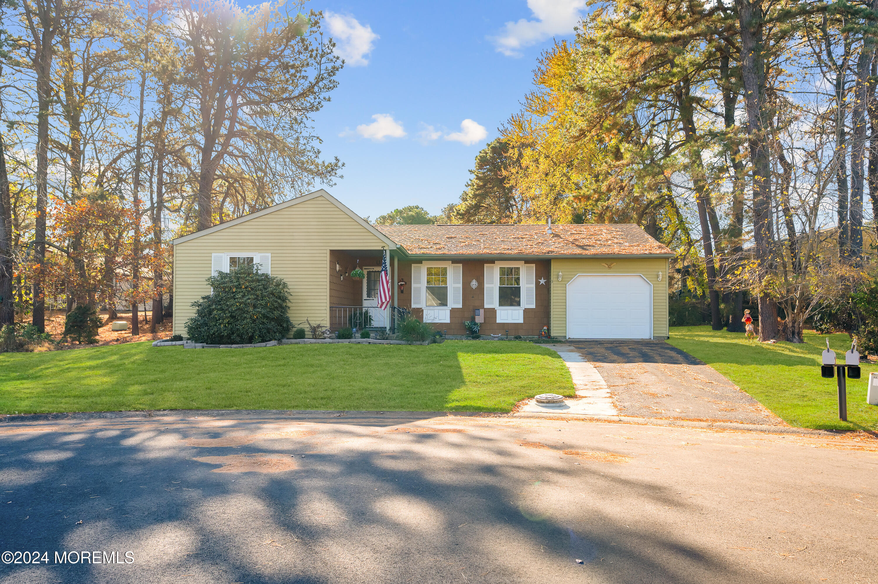 a front view of a house with a yard and trees