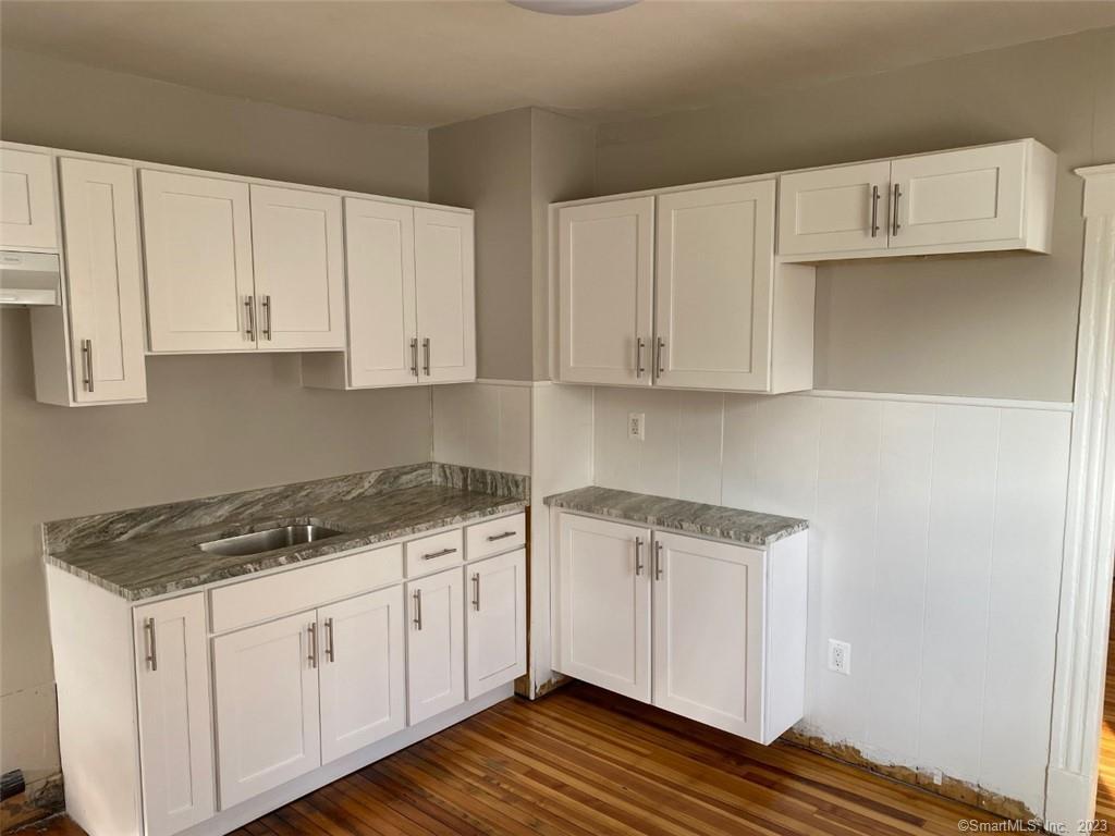 a kitchen with cabinets appliances and a wooden floor