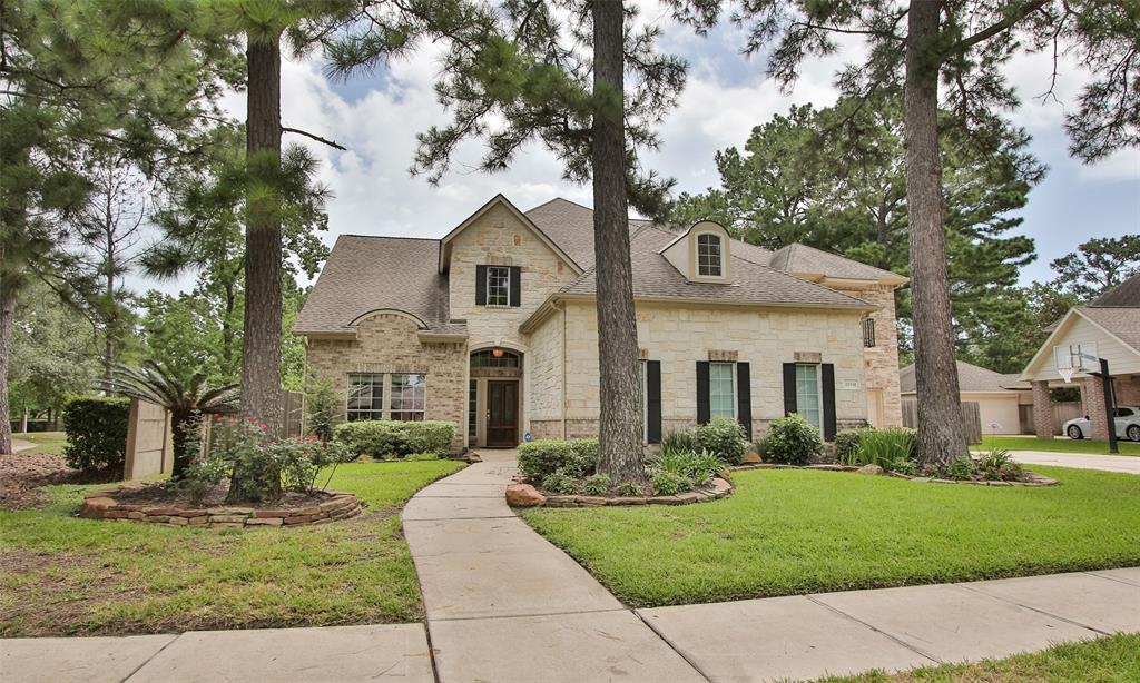 a front view of a house with a yard and trees