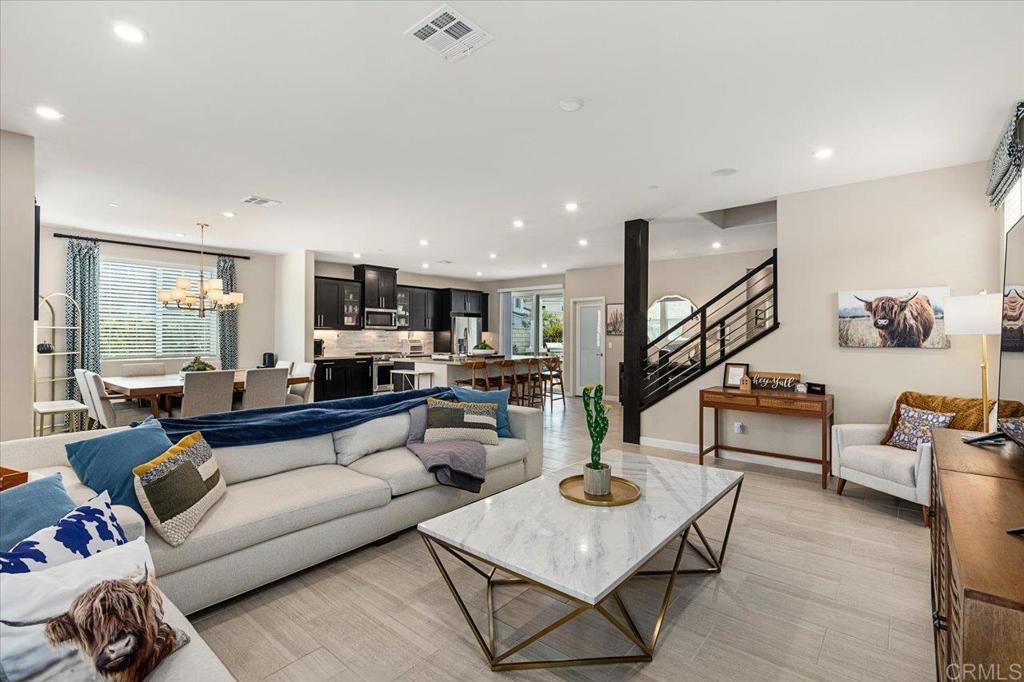 a living room with furniture and a view of kitchen